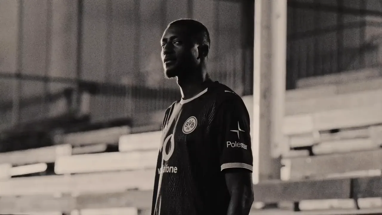 Serhou Guirassy im BVB-Trikot auf der Tribüne des Stadions Rote Erde, Schwarzweiß in Sepia